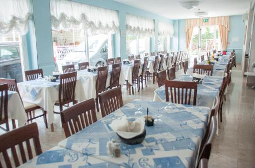 里米尼米拉齐奥艾尔博格别墅酒店的一间配备有蓝白色桌椅的用餐室