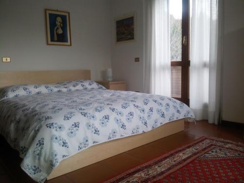 佩鲁贾波斯切托旅馆的一间卧室配有一张带蓝色和白色棉被的床