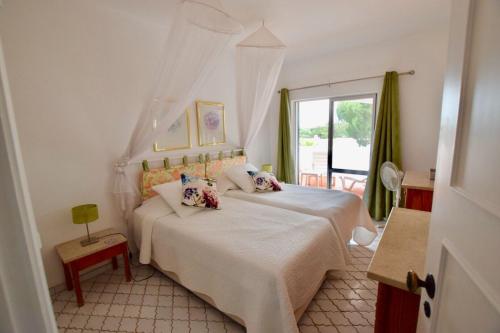 韦尔都勒博Villa Oleander的卧室配有白色的床和窗户。