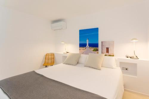 埃斯普霍斯Apartamentos Roca Plana的一间卧室配有一张白色的床,享有灯塔的景色