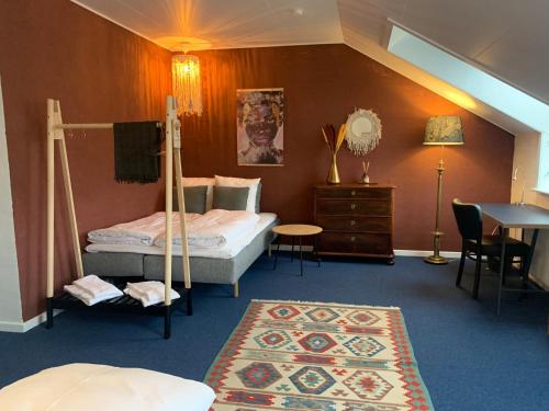 腓特烈西亚加美尔哈富恩酒店的一间卧室配有两张床、一张桌子和一张地毯。