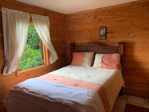 PoásLa Cabaña Poas的一间卧室配有一张床,内设窗户