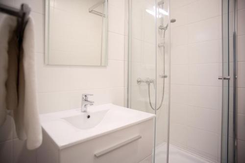 滨湖波德斯多夫Haus56的浴室配有盥洗盆和带镜子的淋浴