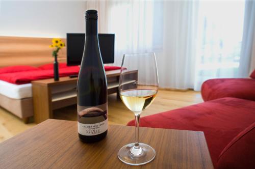 Rohrendorf bei KremsWinzerhaus Kitzler的一瓶葡萄酒和一张桌子上的一杯