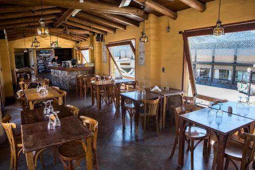 蒂尔卡拉阿拉阿尔玛山林小屋的一间带桌椅的餐厅和一间酒吧