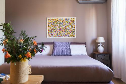 曼杜里亚Tenuta Cardinale的卧室配有一张床,墙上挂有绘画作品