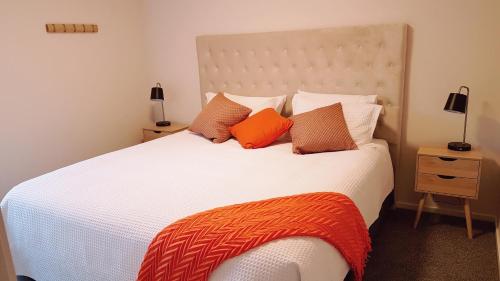 克莱德128 on Hazlett的卧室配有带橙色枕头的大型白色床