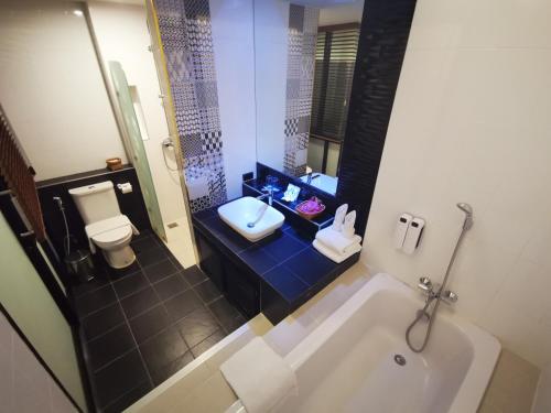 洛坤府曼迪诺克酒店的带浴缸、卫生间和盥洗盆的浴室