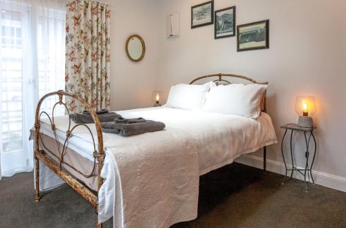 泰晤士库拉努伊度假屋的一间卧室配有一张带白色床单的床和一扇窗户。