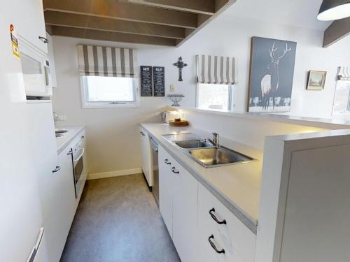 佩里舍峡谷Lodge Chalet 16 - The Stables Perisher的白色的厨房设有水槽和台面