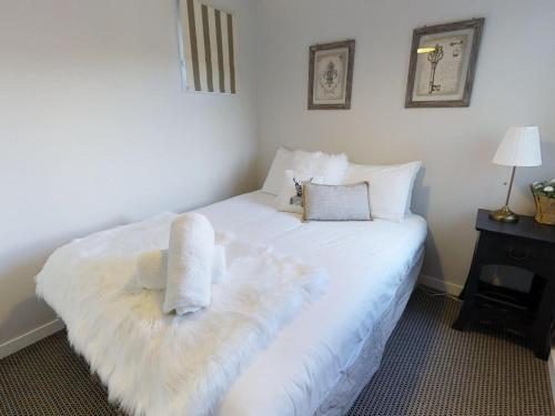 佩里舍峡谷Lodge Chalet 16 - The Stables Perisher的卧室配有白色床和毛巾