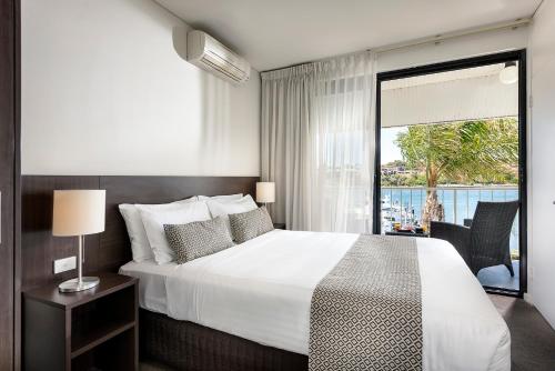 弗里曼特弗里曼特尔21号码头公寓酒店的一间卧室设有一张大床和一个大窗户