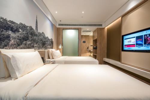 杭州杭州西湖湖滨亚朵酒店的酒店客房设有两张床和一台平面电视。