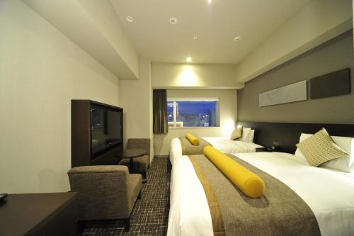 广岛广岛华盛顿酒店的酒店客房设有两张床和一台平面电视。