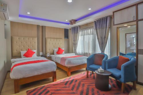 PashupatināthHotel Marinha的酒店客房,配有两张床和两把椅子