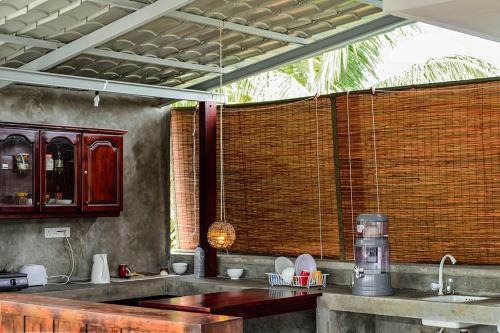 拉维尼亚山Colombo Beach Hostel的一个带水槽和大窗户的厨房