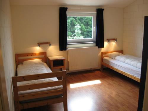 比林根Oberes Ourtal Lodge的客房设有两张床和窗户。