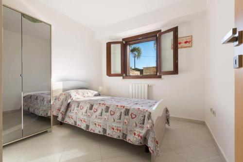 帕拉比塔Dependance di Villa Melissa的一间卧室配有一张床、镜子和窗户