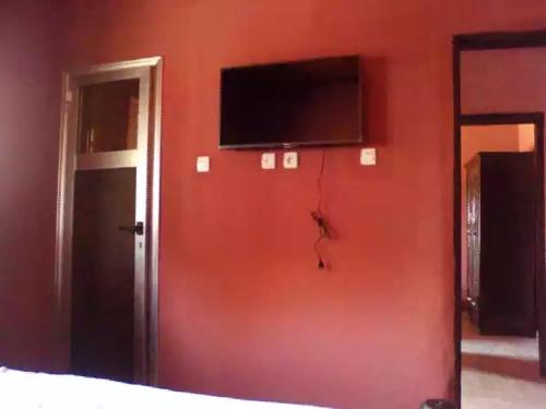 科纳克里HAKABA的一间设有红色墙壁的房间,里面配有电视