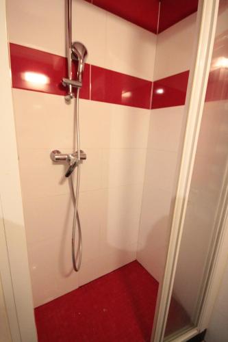 巴黎亚莫公寓式酒店75012的浴室铺有红色和白色瓷砖,设有淋浴。