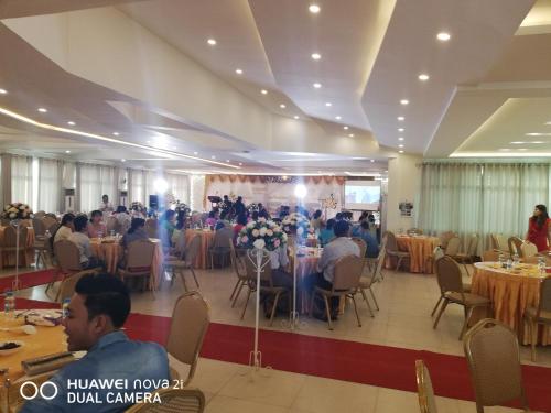 仰光Supreme Hotel Yangon的一群坐在宴会厅桌子上的人