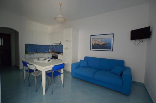 托雷瓦多Holiday Apartments Azzurro Salento的客厅配有蓝色的沙发和桌子