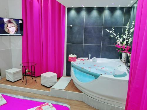 那不勒斯Red House的带浴缸、电视和粉红色窗帘的浴室
