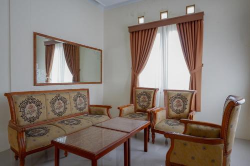 KaranganyarRedDoorz near Stadion 45 Karanganyar的客厅配有沙发、两把椅子和一张桌子