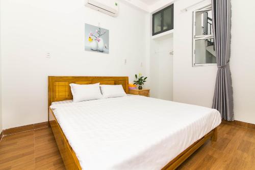 岘港SPOT ON 806 Net Viet Homestay的一间卧室配有一张带白色床单的床和一扇窗户。