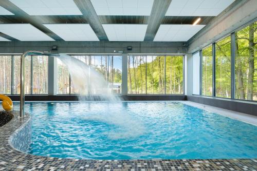 米兹多洛杰Aquamarina Onyx Marina Invest的一座建筑物内带喷泉的游泳池