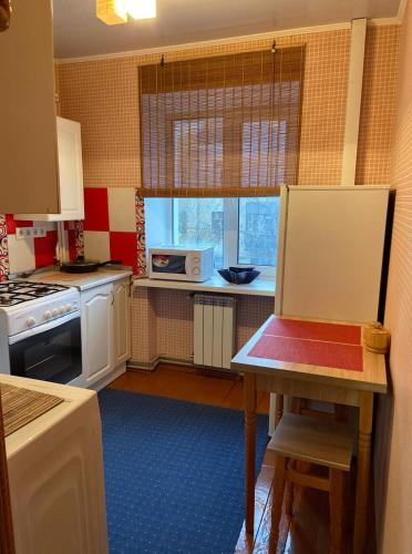 日托米尔Михайлівська квартира的一间带桌子和微波炉的小厨房