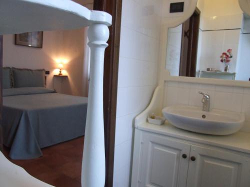 萨塞塔Villa il Castagno的一间带水槽的浴室和一张带镜子的床