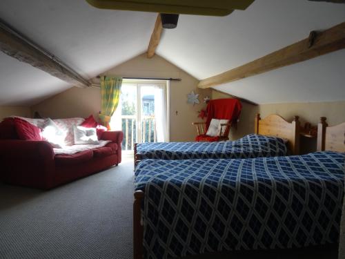 GorronCharming French cottage in the heart of quiet Gorron的一间带两张床和一张沙发的卧室