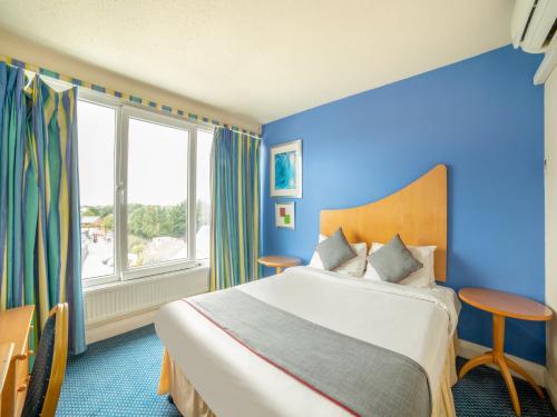 卢顿OYO The Chiltern Hotel的酒店客房设有一张床和一个大窗户