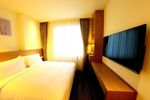 宜兰市26旅店的配有一张床和一台平面电视的酒店客房
