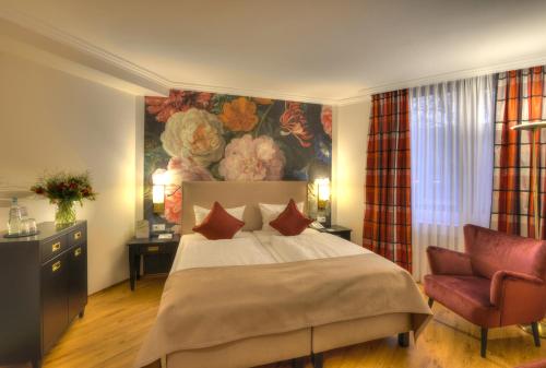 特里尔尼尔斯公园酒店的卧室配有一张床,墙上挂有绘画作品