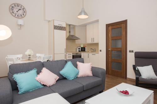 博尔德斯·代瓦里拉Apartamento cerca de Pistas的客厅配有带粉红色和蓝色枕头的灰色沙发。