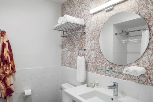 罗利The Longleaf Hotel的白色的浴室设有水槽和镜子