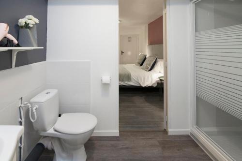 OetingHôtel Le Lys的一间带卫生间的浴室和一间带一张床的卧室