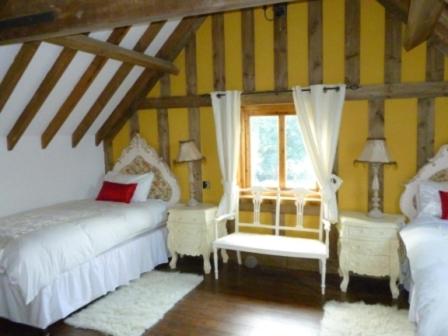布里奇沃特老车库度假别墅的阁楼卧室设有两张床和窗户。