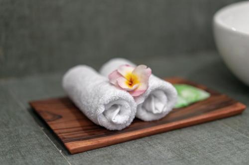 蓝梦岛Nusa Indah Onai Hotel的一堆毛巾和一朵花在木板上