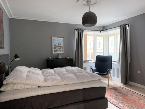 哥本哈根ApartmentInCopenhagen Apartment 1423的卧室配有一张白色大床和一把椅子