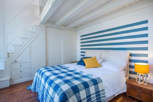 巴勒莫Terrazza al Capo by Wonderful Italy的一间卧室配有一张带蓝白色条纹墙的床