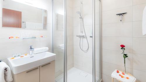 圣卡尼兹克洛彭尼斯湖畔酒店的带淋浴和盥洗盆的白色浴室