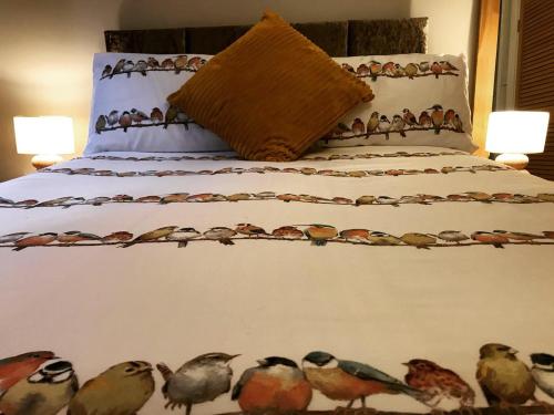 WombournClarabel's Guest House- The Nook的一张床上涂着一群鸟儿的睡床