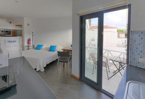 奥尔塔Faial Marina Apartments 1的厨房配有一张床和一个阳台