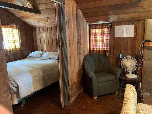 坎莫尔Rundle Chalets的一间卧室,卧室内配有一张床和一把椅子
