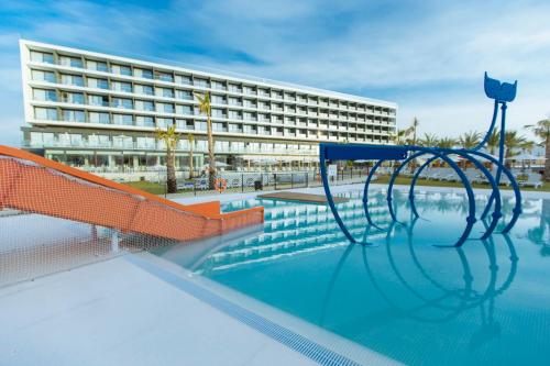 马萨龙港30º Hotels - Hotel Dos Playas Mazarrón的一座游泳池,其背后是一座大型建筑