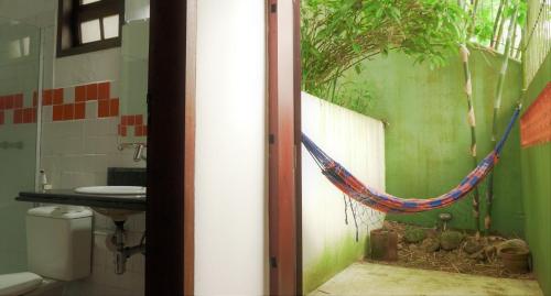 帕拉蒂Pousada Solar D Alcina的浴室配有吊床,墙上挂着一棵树