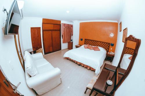卡塔赫纳Baluarte Cartagena Hotel Boutique的一间卧室配有一张床、一张沙发和一把椅子
